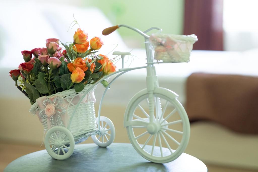 - un vélo blanc avec un panier de fleurs sur une table dans l'établissement Vakhtang Gorgasali apartment, à Tbilissi