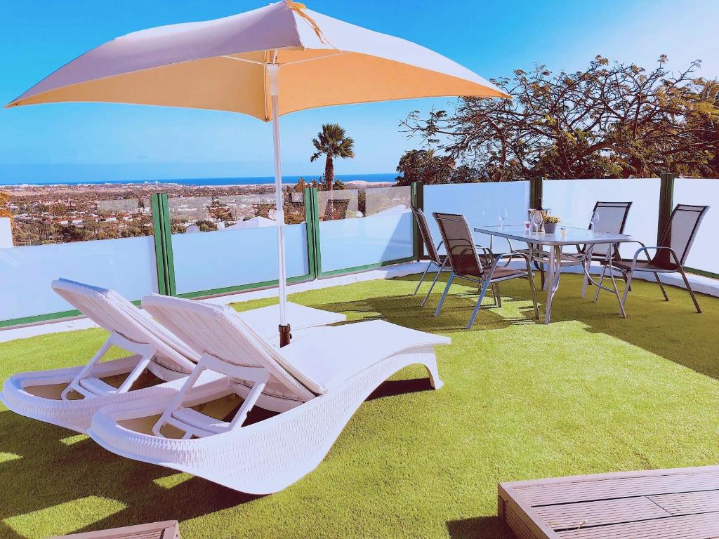 a patio with a table and chairs and an umbrella at Vista Dorada 7A in Maspalomas