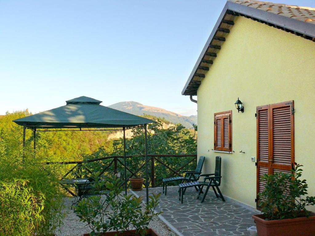 Cette maison dispose d'une terrasse avec un parasol vert. dans l'établissement B&B Terra Di Mezzo, à Ascoli Piceno