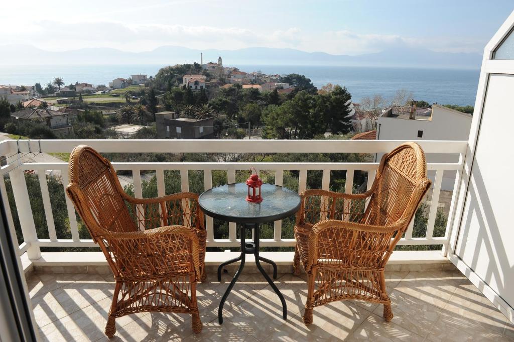 una mesa y sillas en un balcón con vistas al océano en Apartments Lončar en Gradac