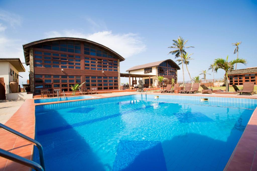 a large swimming pool in front of a building at The Palms at Prampram in Prampram