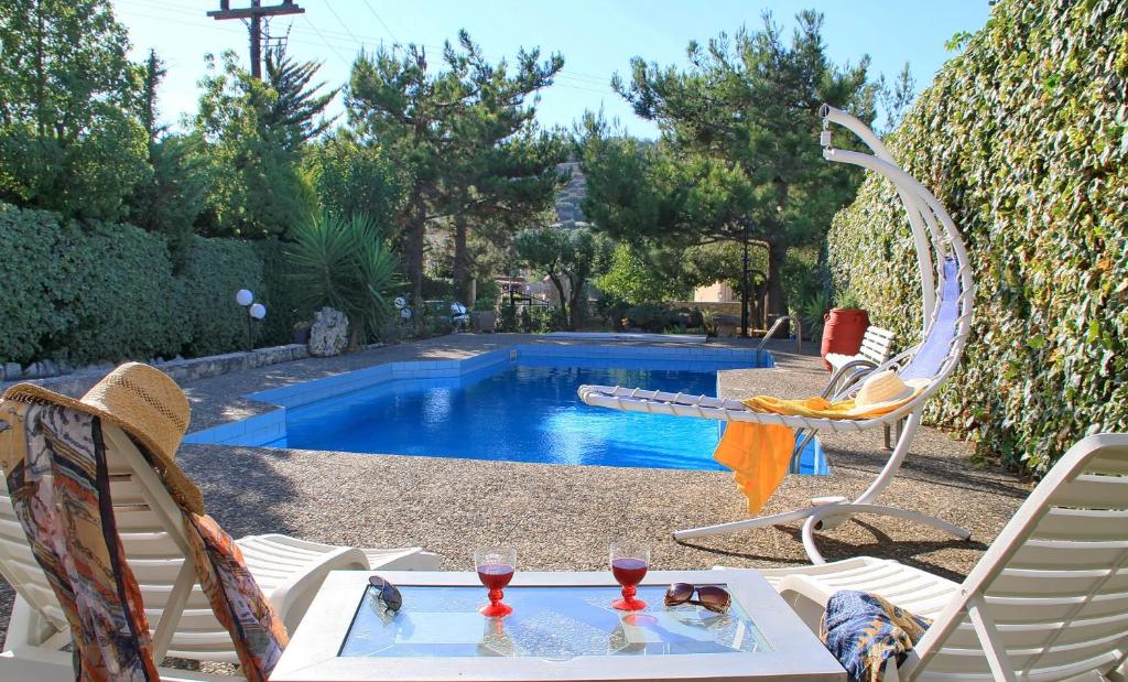een zwembad met een tafel en twee stoelen en een tafel sidx sidx sidx bij Villa Kazantzakis in Archanes