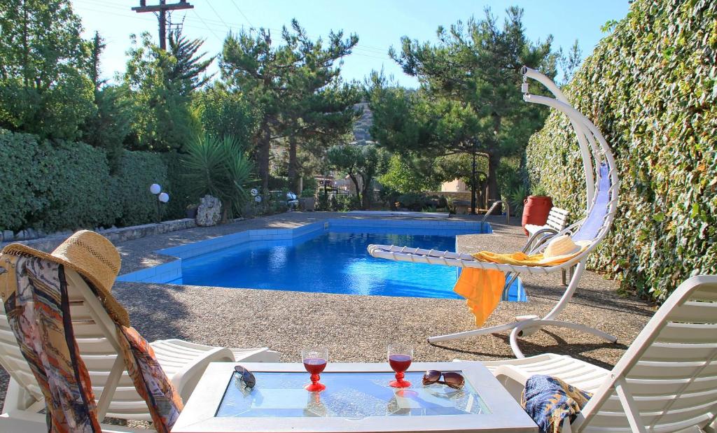 Una piscina con una mesa y dos sillas y una mesa Sidx Sidx Sidx Sidx Sidx Sidx. en Villa Kazantzakis, en Archanes