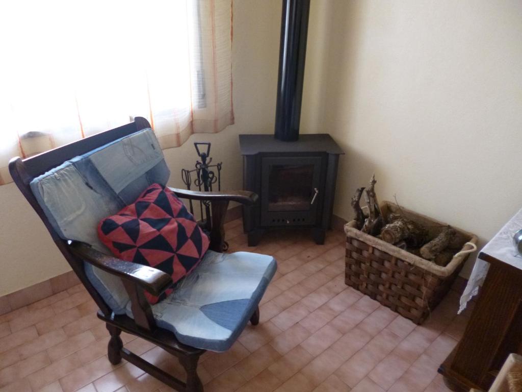 a living room with a chair and a fireplace at Casa de Santana in Arneiro