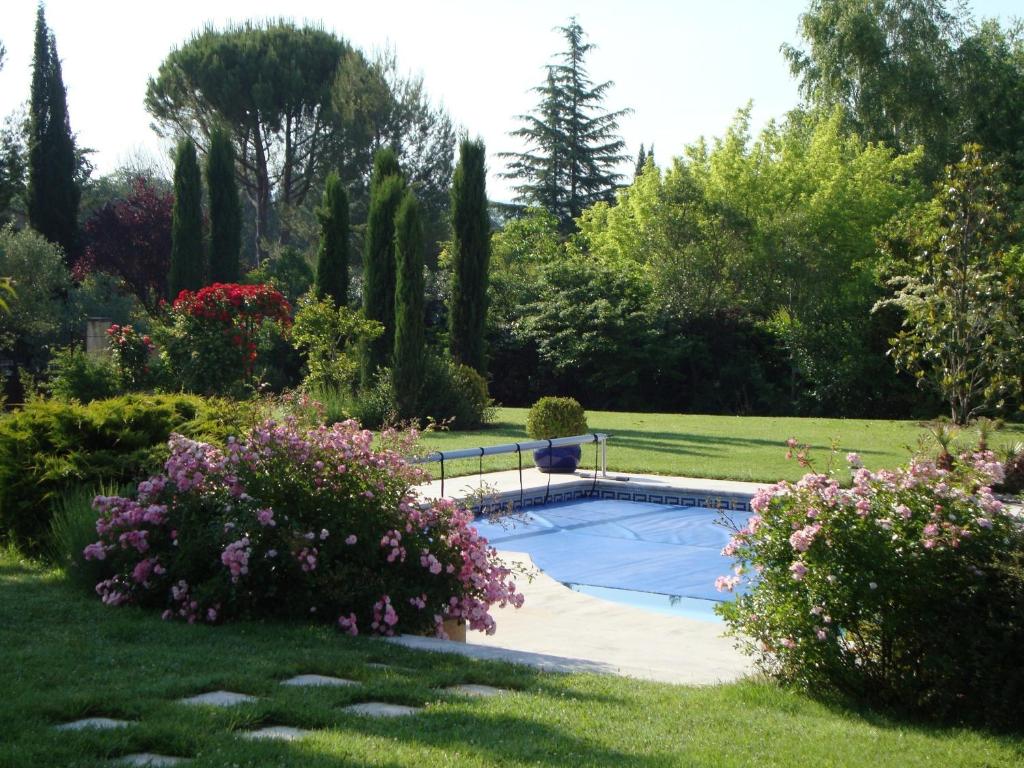 einen Pool in einem Garten mit Blumen und Bäumen in der Unterkunft La Guéritaulde in La Tour-dʼAigues