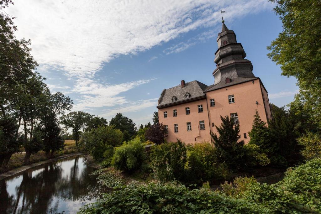 un castillo con un río delante de él en Gut Dyckhof, en Meerbusch