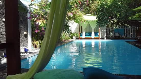 a large swimming pool in a yard with trees at La Marina Boutique Hotel & Spa in Mui Ne