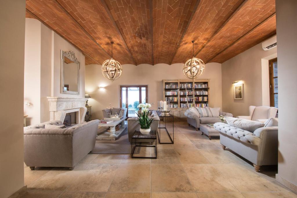 a living room with couches and a fireplace at Borgo Argiano in Castelnuovo Berardenga
