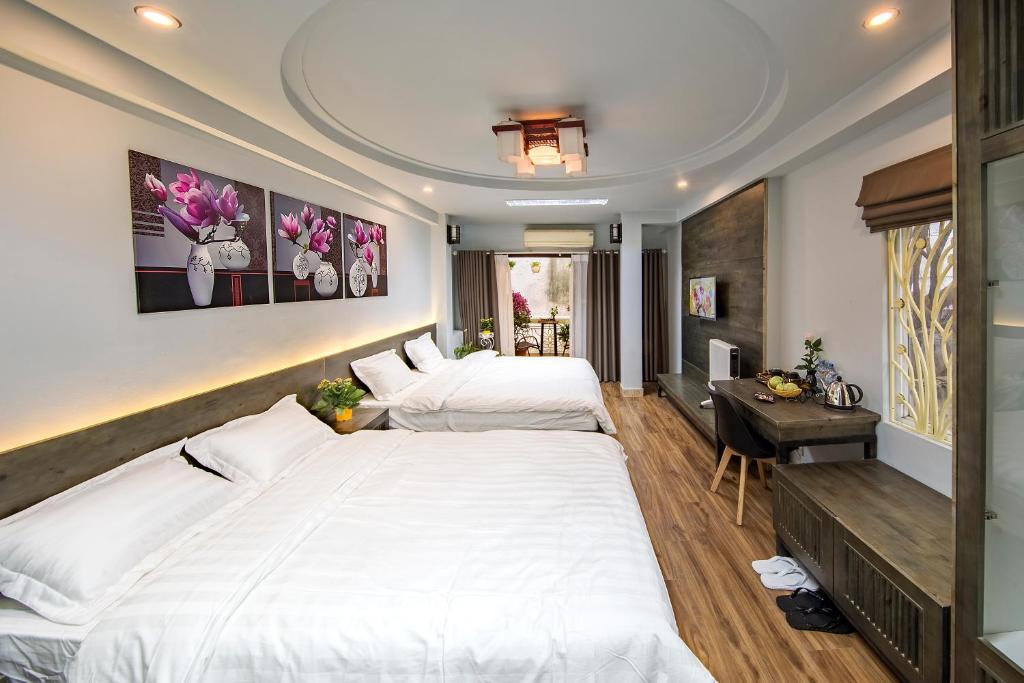 a bedroom with two beds and a desk in it at Hanoi Moon Cactus in Hanoi