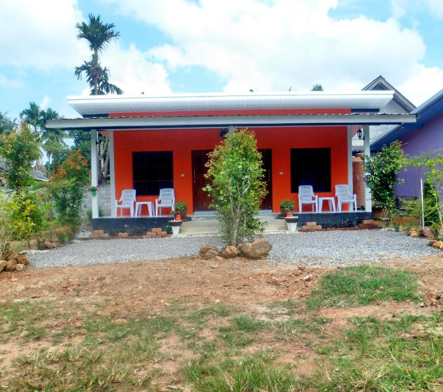 ein Haus mit weißen Stühlen davor in der Unterkunft Be Faanny House in Ko Lanta