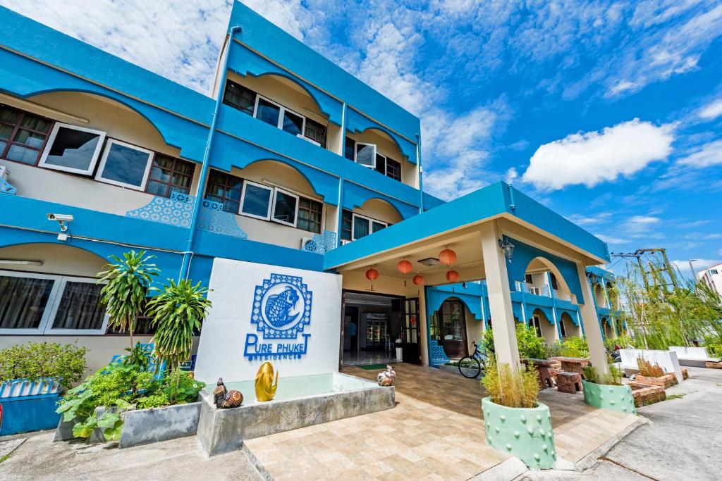 a blue building with a sign in front of it at Pure Phuket Residence in Phuket