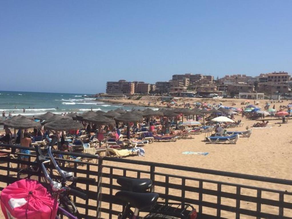 a beach with umbrellas and people on the beach at Apartment La Mata LM004 in La Mata