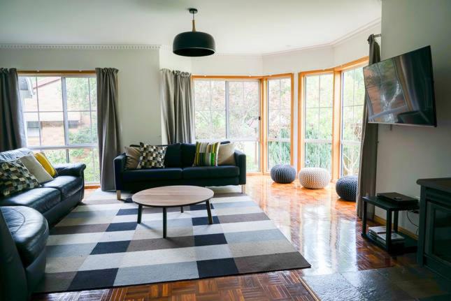 a living room with a couch and a table at Canyon Walk House & Unit in Bright