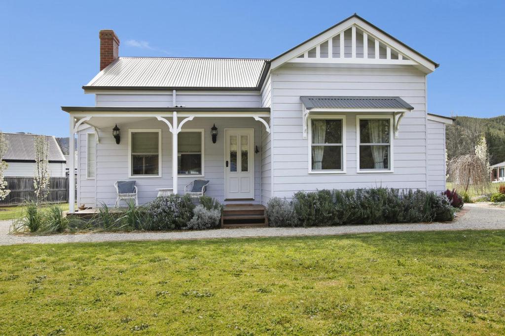 a white house with a lawn in front of it at Collins Cottage in Bright