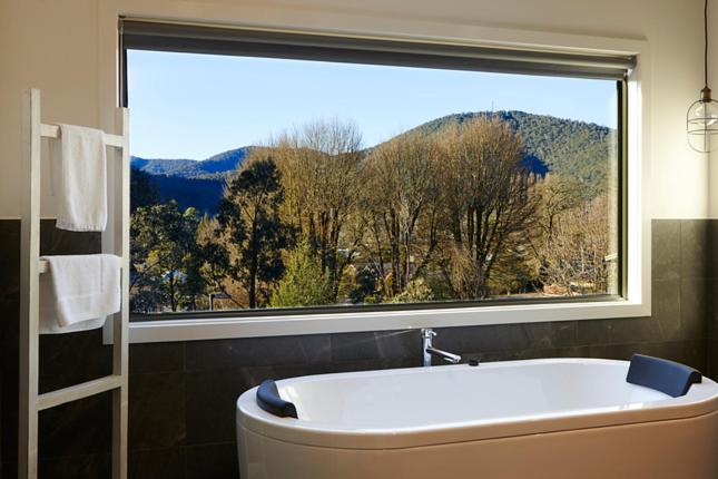 a bath tub in a bathroom with a large window at BLUEhaven....@BRIGHT in Bright