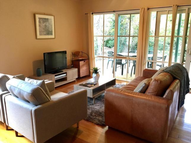 a living room with two couches and a television at Corinda Cottage - 4 bedroom pet friendly in Bright