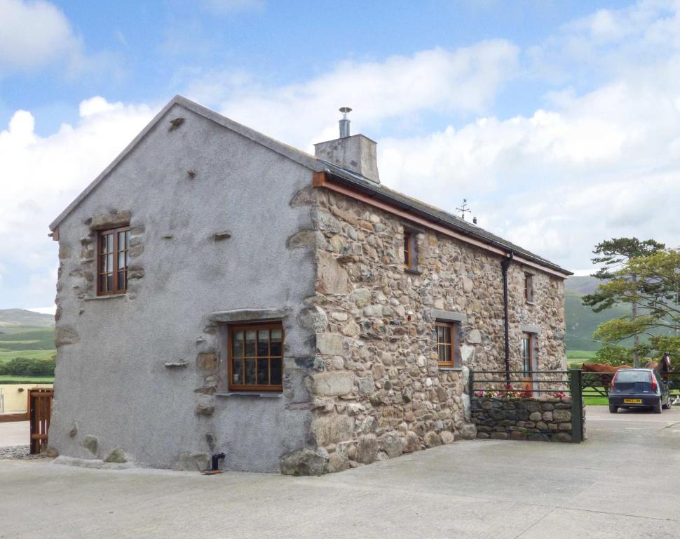 un viejo edificio de piedra con una cruz encima en Fell View Cottage en Bootle