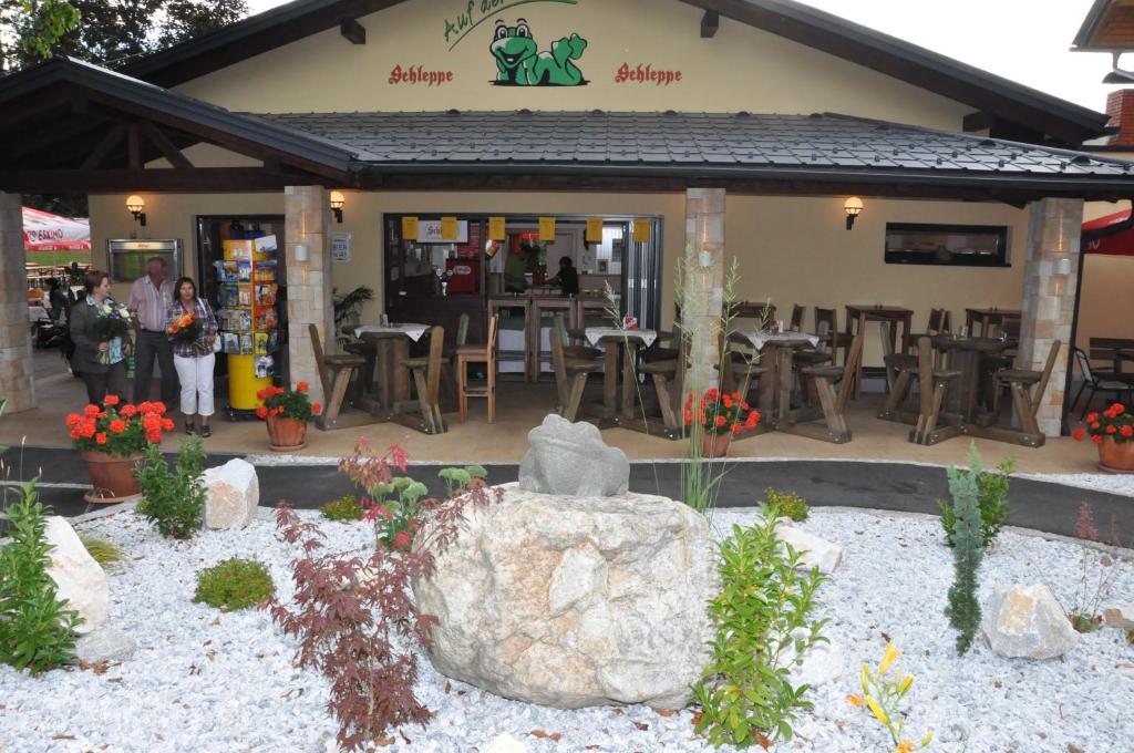 a restaurant with a large rock in front of it at Gasthof Plasch in Ferlach