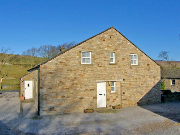 a large brick building with two white doors at Barnbrook in Carperby