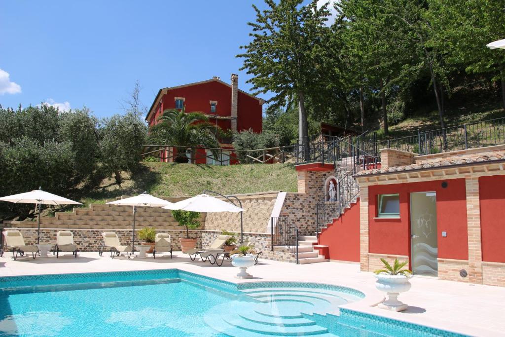 una piscina con sedie e ombrelloni accanto a un edificio di Casa Sacciofa a Monte Rinaldo