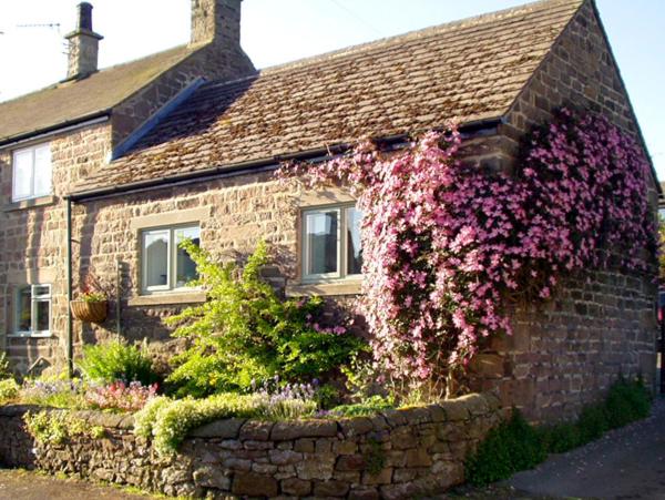 a brick house with pink flowers on the side of it at Cobbled Corner in Elton