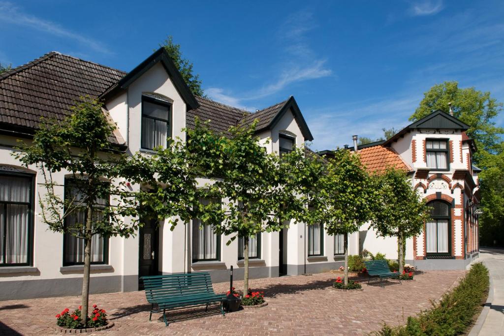 uma casa com um banco verde em frente em Hotel Restaurant Mondriaan em Winterswijk