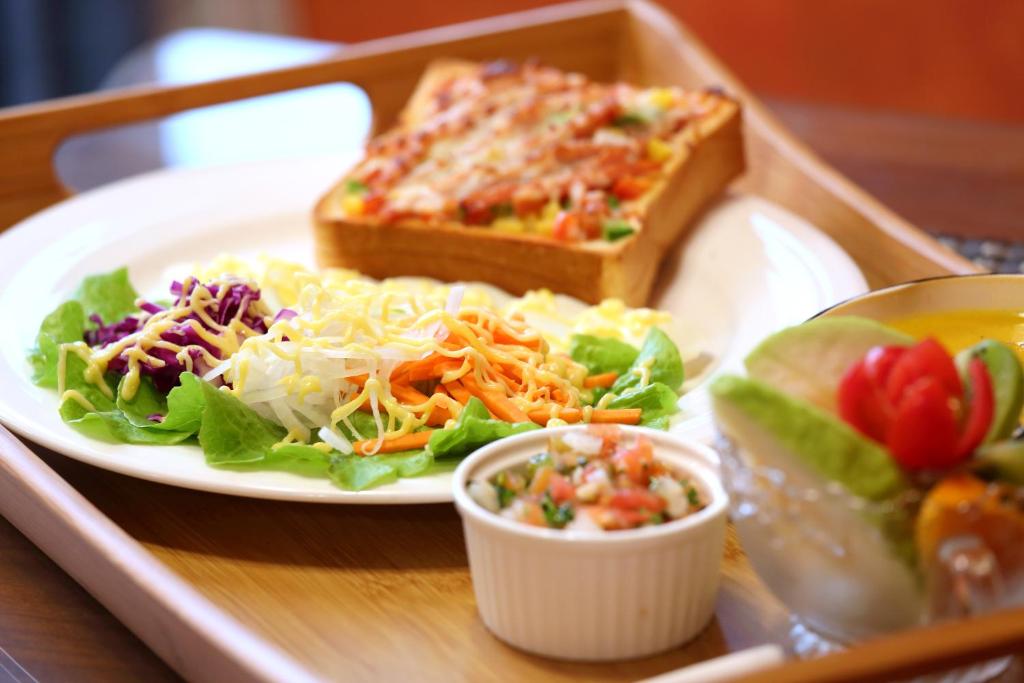 a tray of food with a plate of salad and a sandwich at Beautifl Sweet Warm B&amp;B in Hualien City