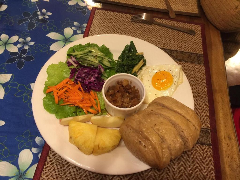 a white plate of food with an egg and salad at Beautifl Sweet Warm B&amp;B in Hualien City