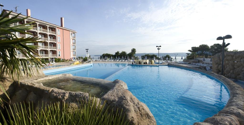 een groot zwembad voor een gebouw bij Hotel Aquapark Žusterna in Koper