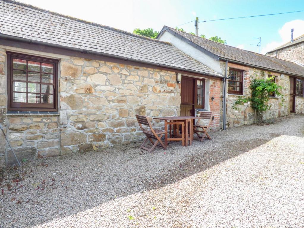 a table and chairs outside of a stone building at The Bullshed in Saint Erth