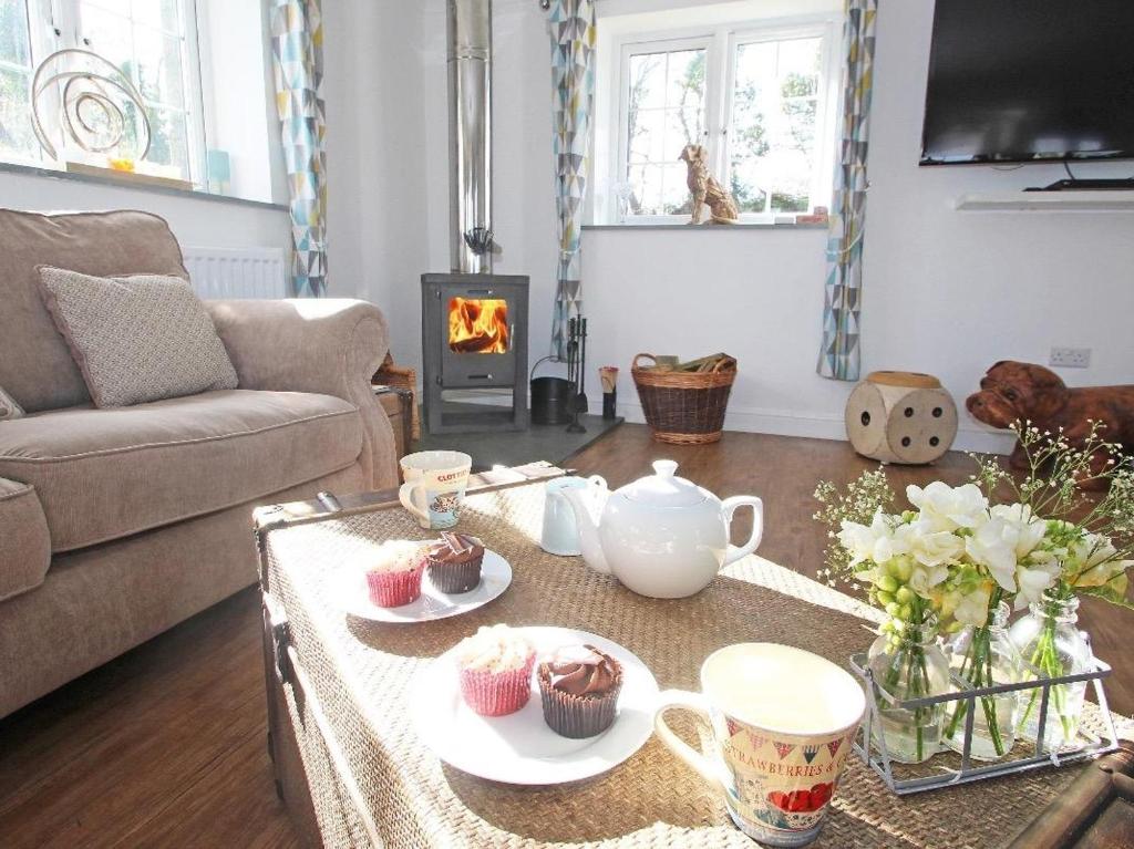 a living room with a coffee table with cupcakes on it at Omalast in Truro