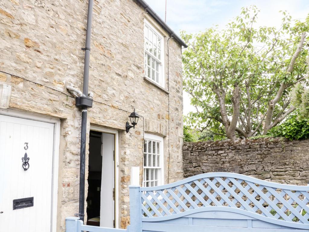 a stone house with a blue bench in front of it at Olive Cottage in Richmond