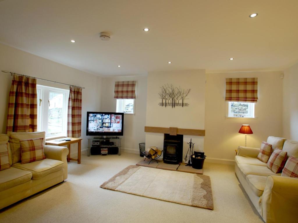 - un salon avec deux canapés et une télévision dans l'établissement Margaret House, à Pooley Bridge