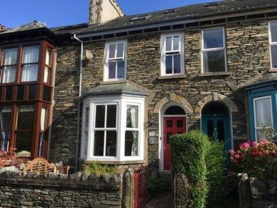 una gran casa de ladrillo con puerta roja y puerta roja en Ingle Burrow, en Windermere