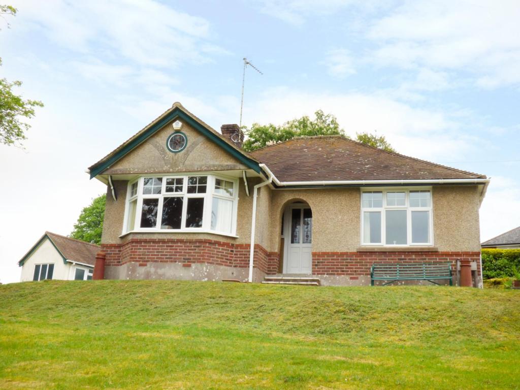 a house on top of a grassy hill at Goodrest in Verwood