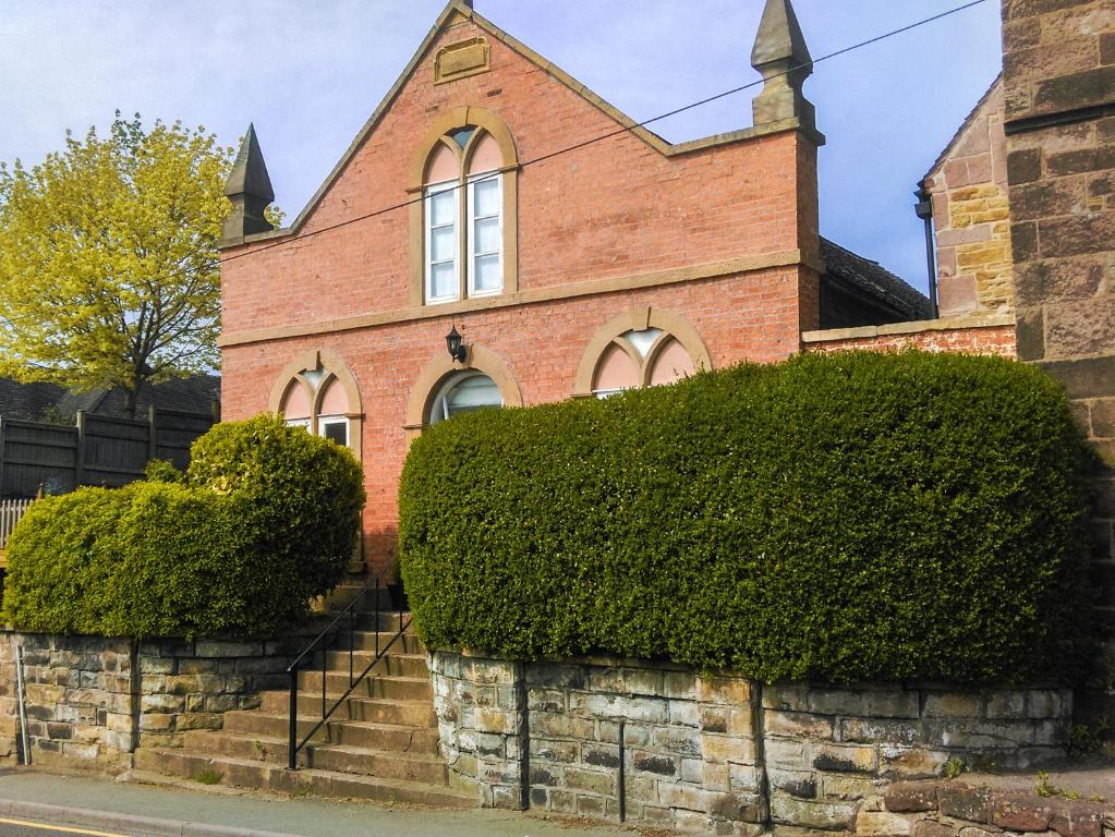 a brick church with bushes in front of it at The Old Temperance Hall in Kingsley