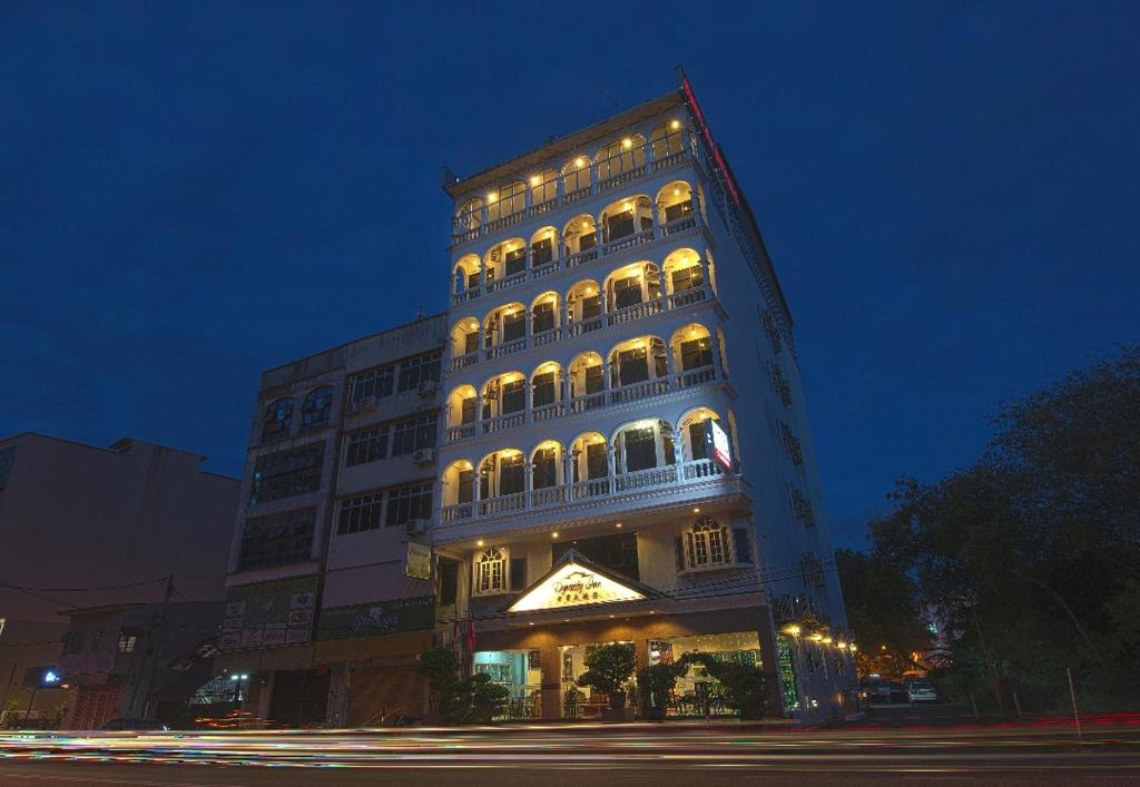 a tall building with lights on it at night at Dynasty Inn in Kota Bharu