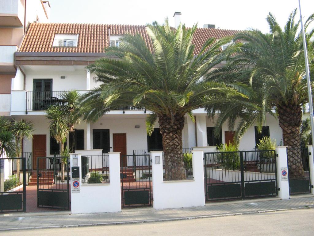 una casa con palme di fronte di Residence Dolcemare a San Benedetto del Tronto