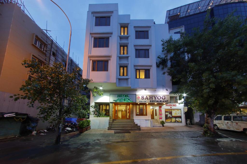 een gebouw met een winkel in een stadsstraat bij Hotel Apex in Surat