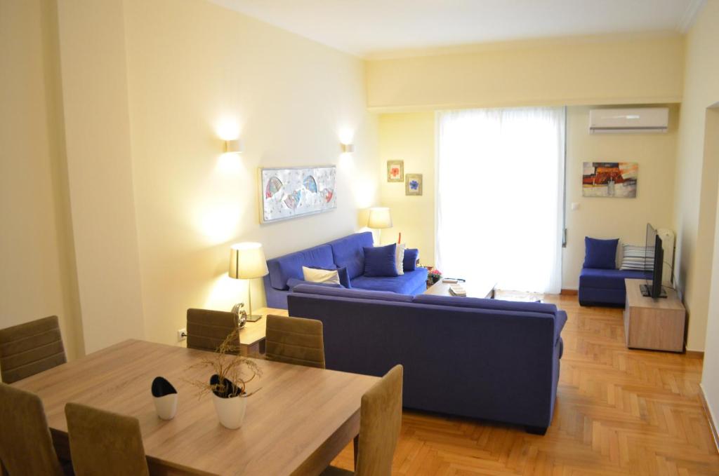 uma sala de estar com um sofá azul e uma mesa em Pedion Areos Park 6 Center 6 em Atenas