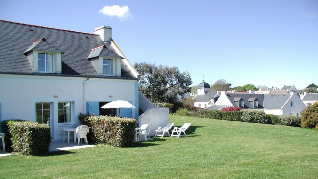 洛克馬里亞的住宿－Maison avec vue sur mer dans Résidence Marie Galante，草坪上带椅子和遮阳伞的房子
