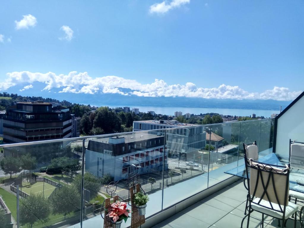 uma varanda com vista para a água e para as montanhas em Swissart | Lake View em Lausanne