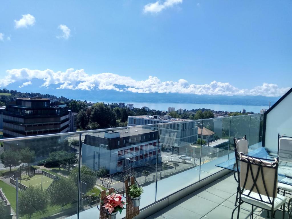 a balcony with a view of the water and mountains at Swissart | Lake View in Lausanne