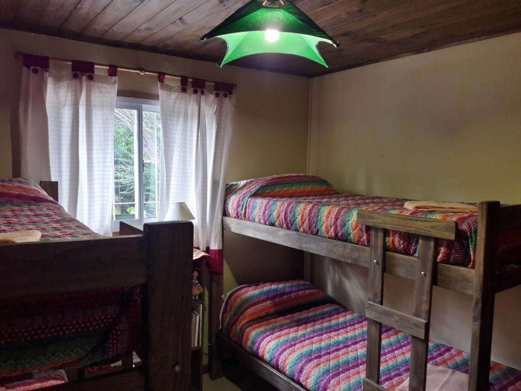 a bedroom with two bunk beds and a green light at Cabañas de Campo in Santa María