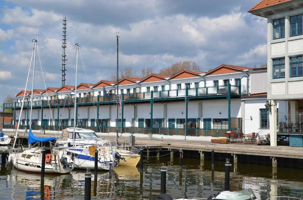 ein Gebäude mit im Wasser angedockten Booten neben einem Dock in der Unterkunft Fewo Koje 22/OVER in Ostseebad Karlshagen