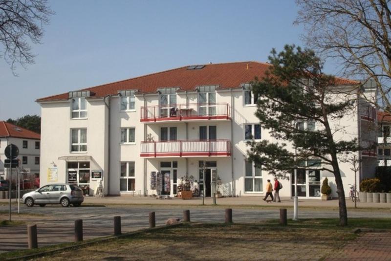 a large white building with people walking in front of it at Fewo Ostseeperle 04_KADO in Ostseebad Karlshagen