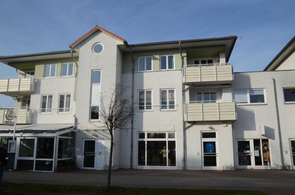 a large white building with windows and balconies at Fewo Oase 28_GROT in Ostseebad Karlshagen