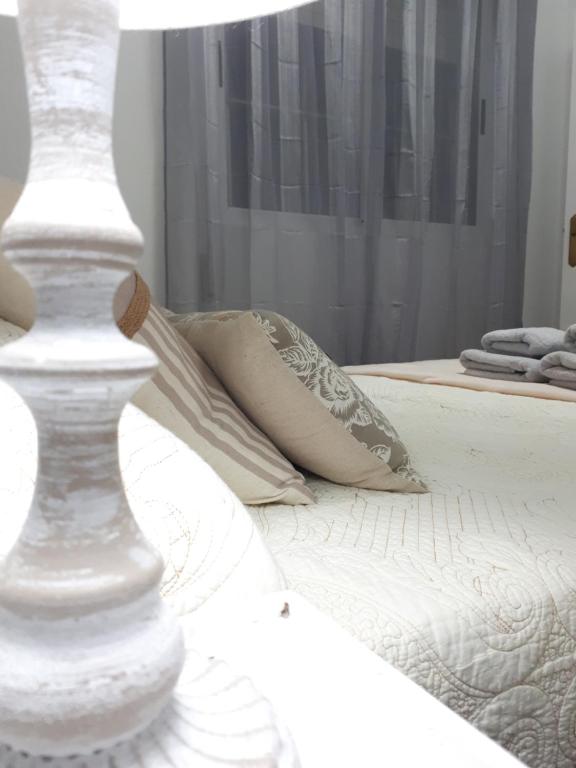 a white bed with a pillow and a lamp at Apartamento Camino de Santiago 2 in Sarria