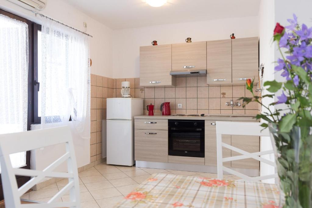 kuchnia z białymi urządzeniami i białą lodówką w obiekcie Apartments Karen w Krku