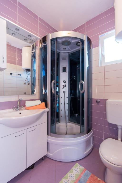 W łazience znajduje się prysznic, umywalka i toaleta. w obiekcie Apartments Karen w Krku